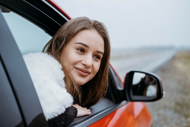 Seitenansicht der Smiley-Frau, die im Auto sitzt