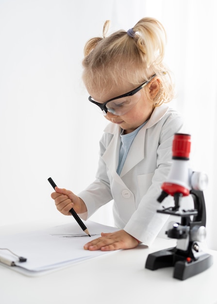Foto seitenansicht des kleinkindes mit mikroskop