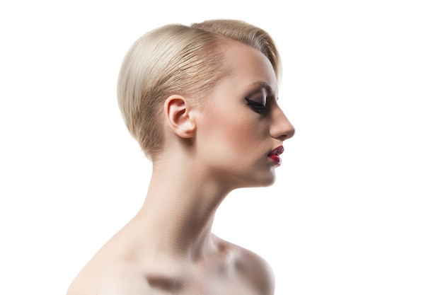 Seitenansicht des kurzhaarigen blonden Mädchens mit roten Lippen und nackten Schultern auf weißem Hintergrund.Isolate