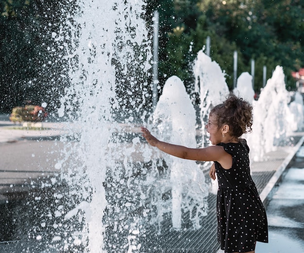 Foto seitenansicht des mädchens am brunnen