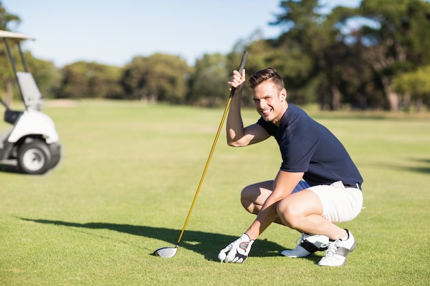 Seitenansicht des Mannes, der Golfball auf Abschlag setzt