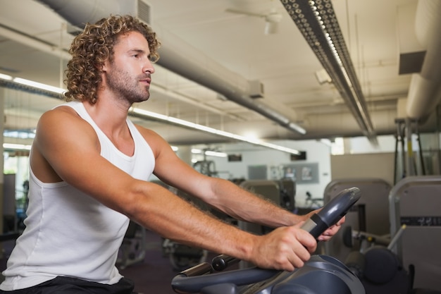 Seitenansicht des Mannes trainierend auf Hometrainer an der Turnhalle