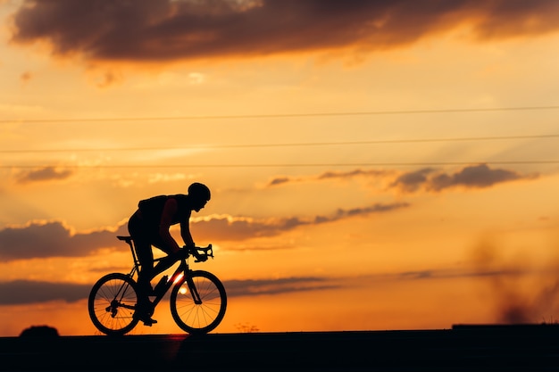 Seitenansicht des professionellen Radfahrers, der Sportaktivität auf schwarzem Fahrrad im Freien tut