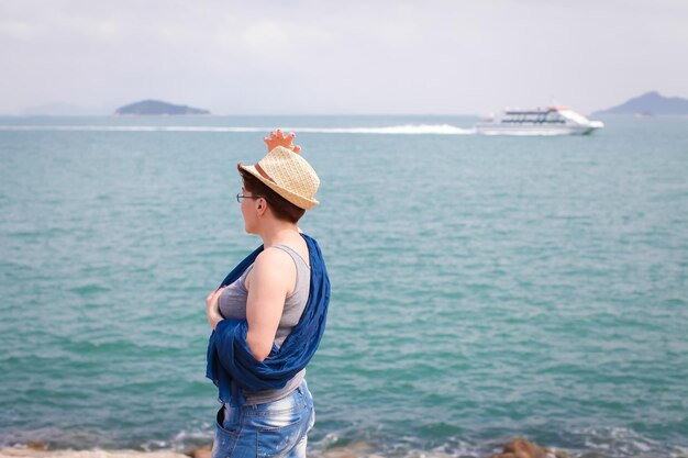 Seitenansicht einer Frau, die auf das Meer gegen den Himmel schaut