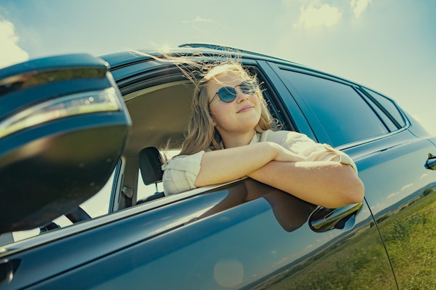 Seitenansicht einer Frau, die auf einem Auto sitzt