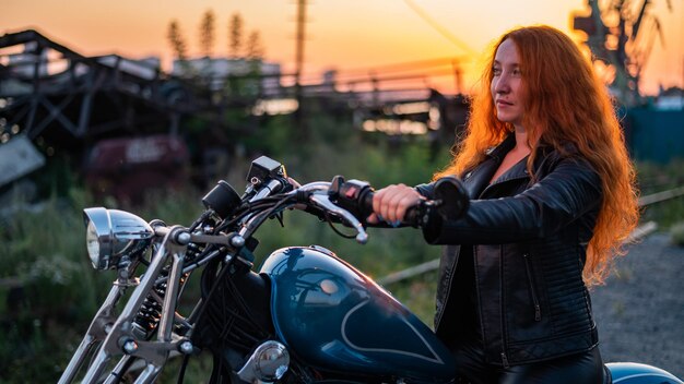 Foto seitenansicht einer frau, die bei sonnenuntergang auf einem motorrad fährt