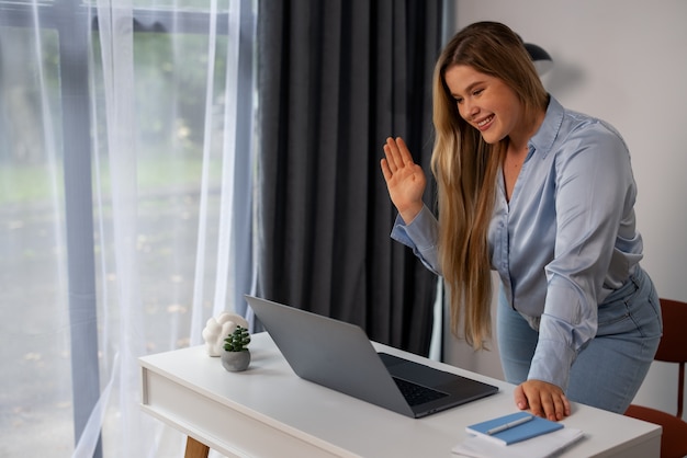 Foto seitenansicht einer frau, die videoanrufe mit einem laptop tätigt