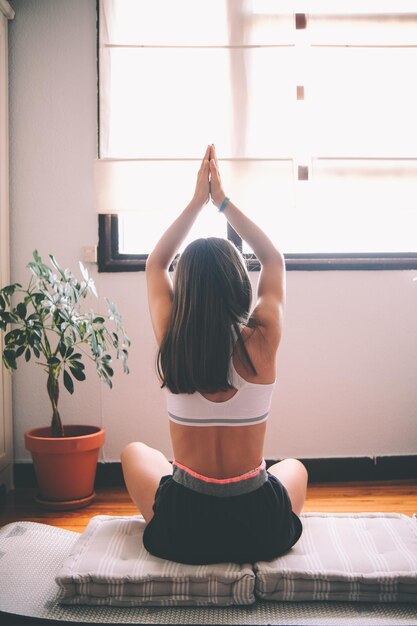 Foto seitenansicht einer frau, die zu hause auf dem tisch sitzt