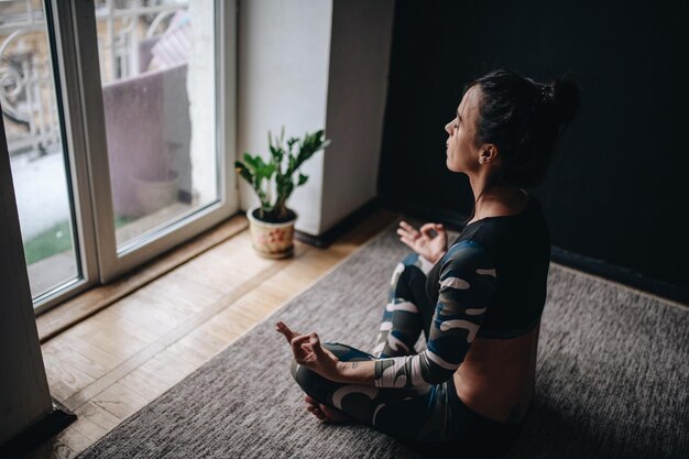 Foto seitenansicht einer frau, die zu hause yoga macht