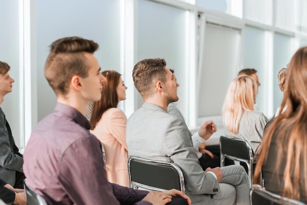 Seitenansicht einer Gruppe junger Geschäftsleute, die im Konferenzraum sitzen