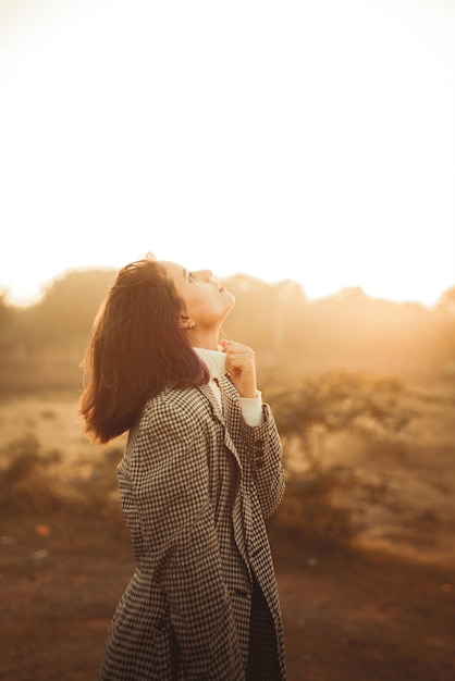 Foto seitenansicht einer jungen frau, die bei sonnenuntergang gegen den himmel fotografiert