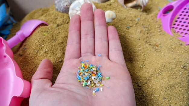 Seitenansicht einer Person, die Mikroplastik in der Hand hält Nicht recycelbare Materialien