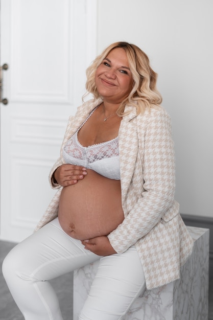 Foto seitenansicht einer schwangeren frau, die im studio posiert