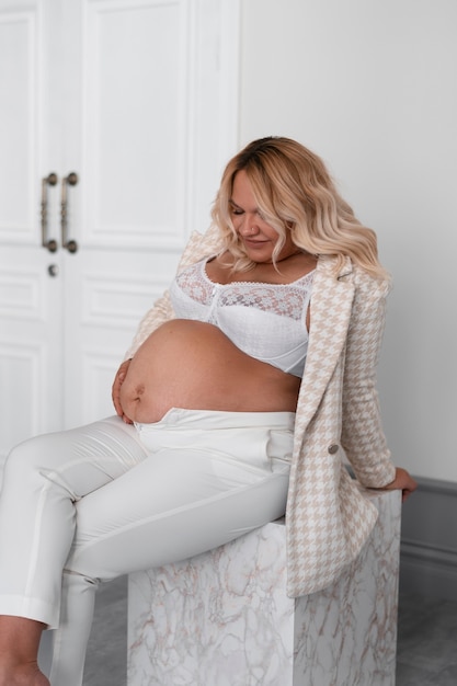 Seitenansicht einer schwangeren Frau, die im Studio posiert