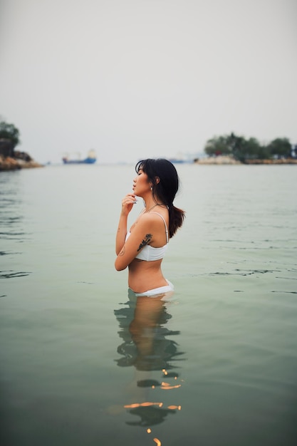 Seitenansicht einer sinnlichen jungen Frau, die Bikini im Meer trägt