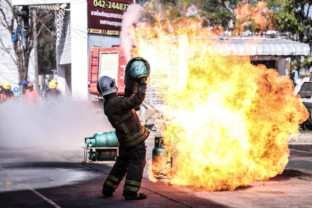 Foto seitenansicht eines feuerwehrmanns, der einen zylinder trägt, während er auf der straße steht