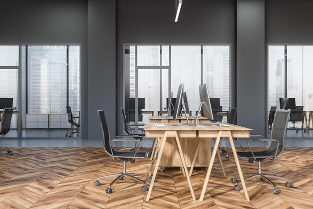 Seitenansicht eines Großraumbüros mit grauen Wänden, Holzboden, großen Fenstern und hölzernen Computertischen mit schwarzen Stühlen. 3D-Rendering