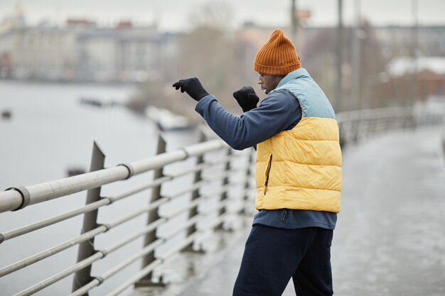 Seitenansicht eines jungen aktiven schwarzen Mannes in Sportbekleidung