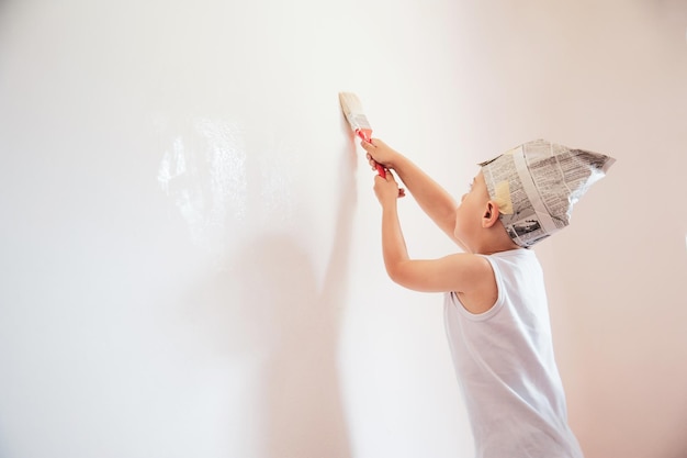 Seitenansicht eines Jungen, der zu Hause an die Wand malt