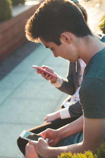 Seitenansicht eines jungen Mannes, der ein Handy benutzt