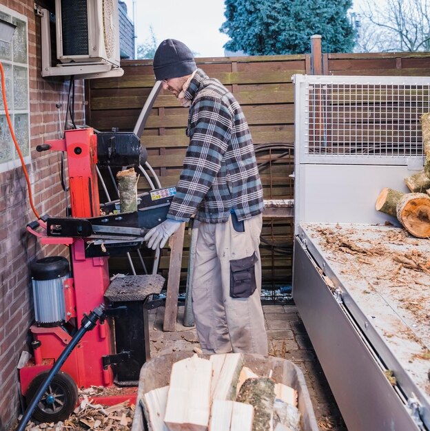 Foto seitenansicht eines mannes, der holz schneidet