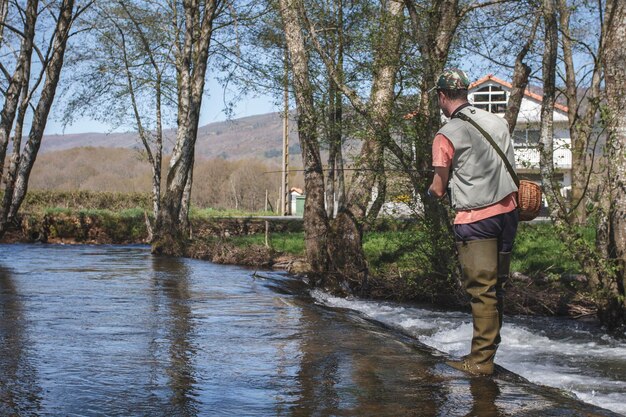 Foto seitenansicht eines mannes, der im fluss fischert