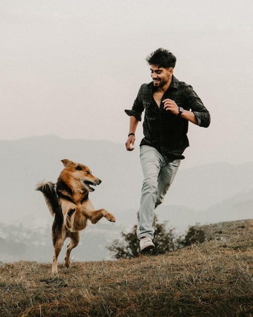 Seitenansicht eines Mannes mit Hunden auf dem Feld gegen den Himmel