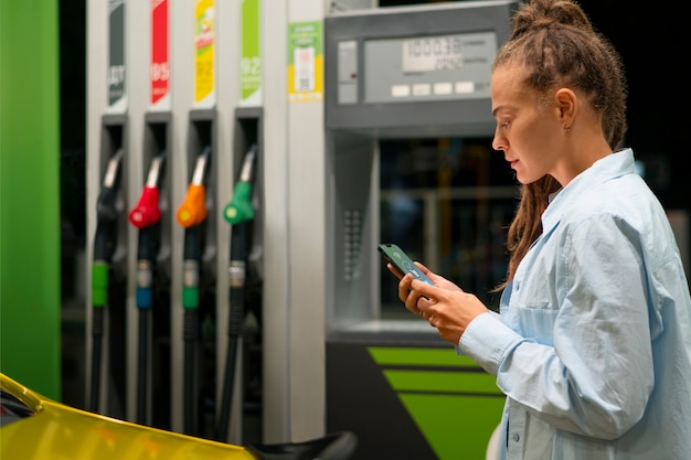 Foto seitenansicht frau an der tankstelle