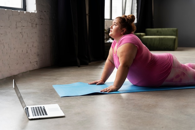 Foto seitenansicht frauentraining mit laptop