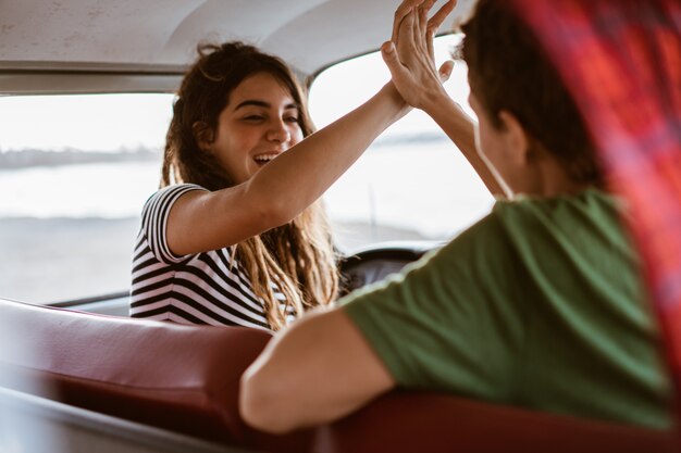 Seitenansicht junges Paar hoch fünf im Auto