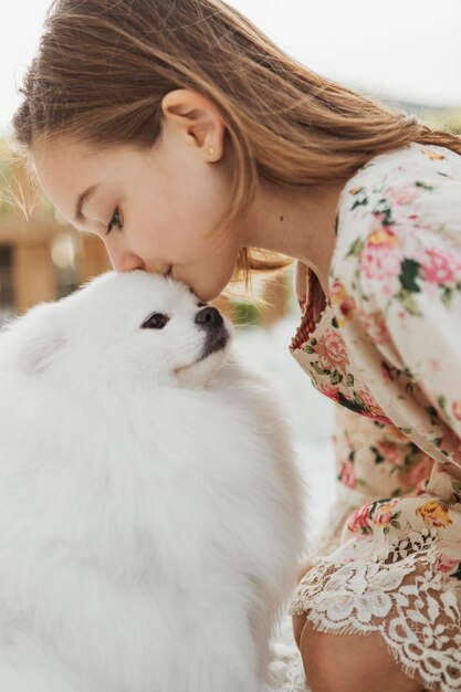 Seitenansicht-Mädchen, das ihren Hund küsst