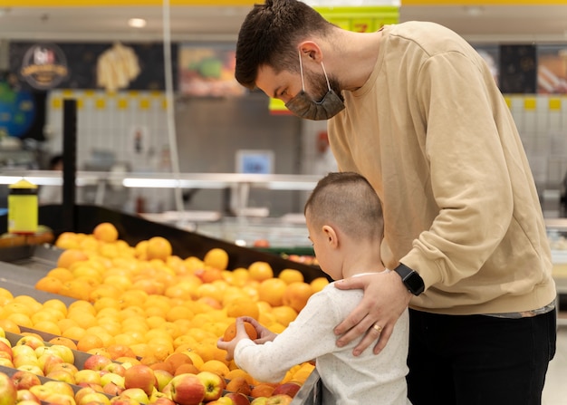 Foto seitenansicht mann mit kind beim einkaufen