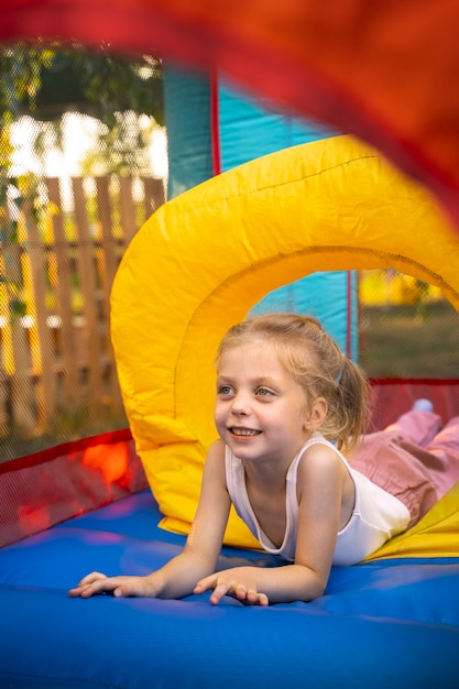 Foto seitenansicht-smiley-mädchen im hüpfburg