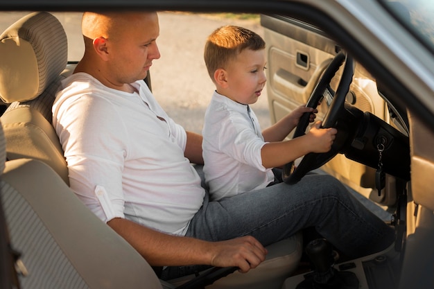 Foto seitenansicht vater und kind im auto