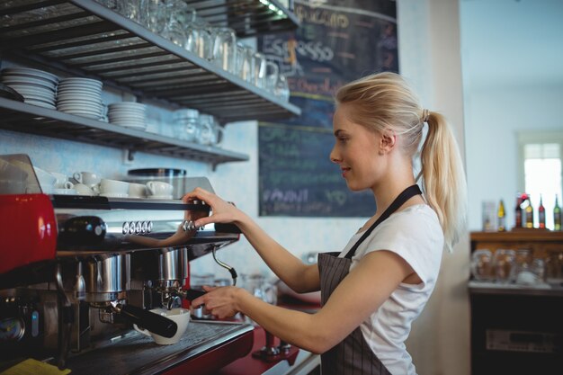 Seitenansicht von barista unter Verwendung der Espressomaschine am Kaffeehaus