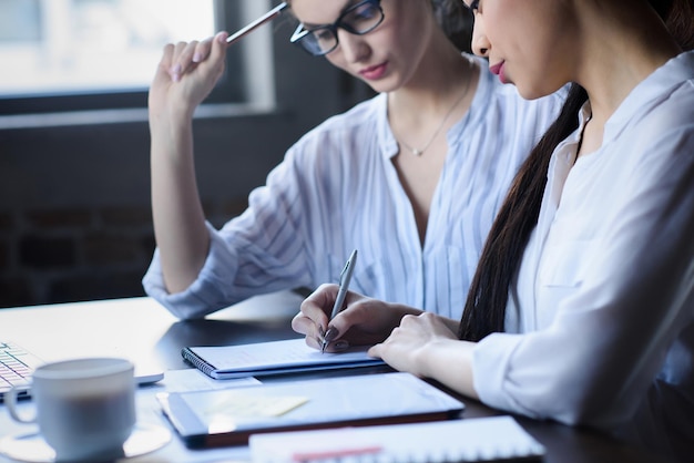 Seitenansicht von Geschäftsfrauen, die gemeinsam über einen neuen Geschäftsplan diskutieren