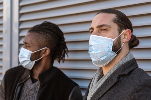 Foto seitenansicht von gutaussehenden männern, die medizinische masken tragen