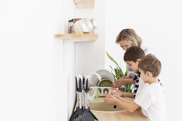 Foto seitenansicht von mutter und kindern, die ihre hände waschen