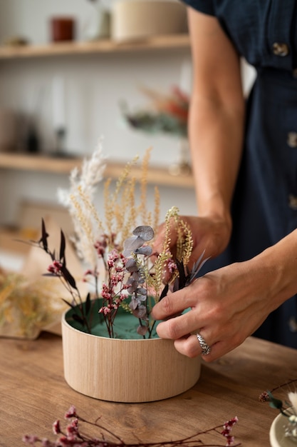 Seitenansichtfrau, die mit Blumen arbeitet