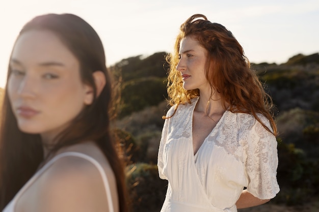 Foto seitenansichtfrauen, die draußen zusammen aufwerfen