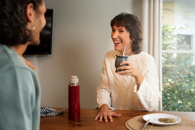 Foto seitenansichtfreunde, die drinnen chatten