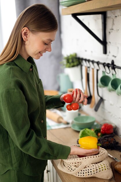 Foto seitenansichtsmileyfrau, die tomaten hält