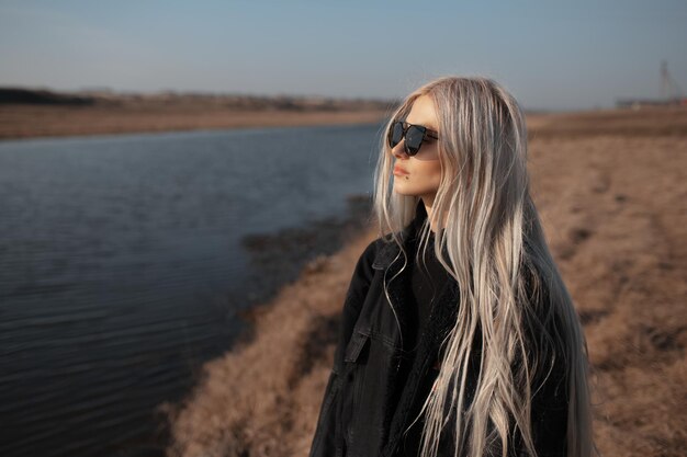 Seitenporträt eines hübschen blonden Mädchens in der Nähe des Flusses