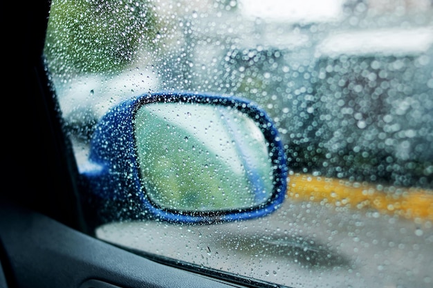 Seitenspiegel auf einem blauen Auto mit Regentropfen