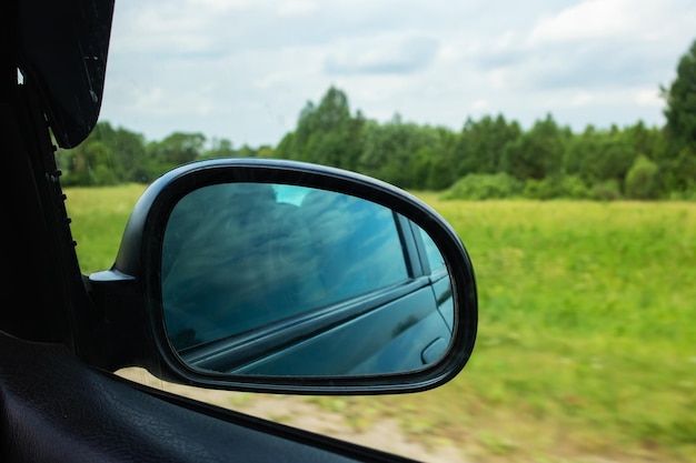 Seitenspiegel des Autos auf dem Hintergrund der grünen Wiese