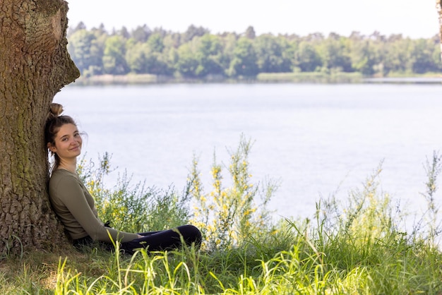 Seitliche Ansicht einer Frau, die auf dem Feld sitzt