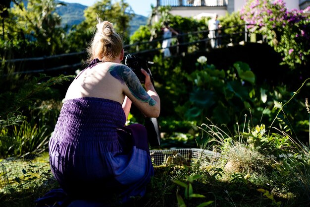 Foto seitliche ansicht einer jungen frau, die im freien sitzt