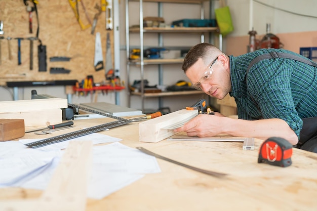 Seitliche Ansicht einer jungen Frau, die in einer Werkstatt arbeitet