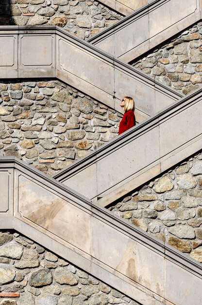 Foto seitliche sicht auf eine reife frau, die auf einer treppe steht