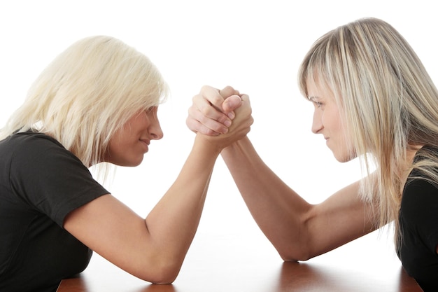 Foto seitliche sicht auf junge frauen, die gegen einen weißen hintergrund armkriegen führen